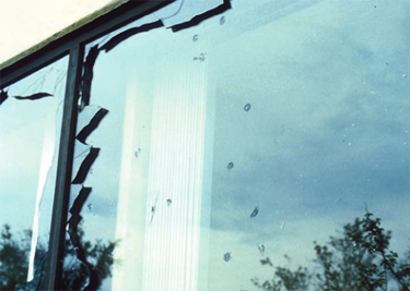 Exterior glazing damage, the outer panes of these windows were broken by aggregate from a built-up roof