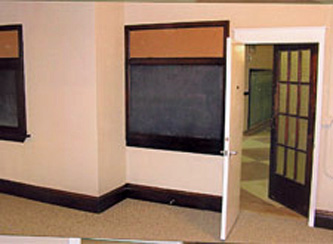 Interior View: Retention of glass doors along historic corridor by incorporating new, code compliant doors on the interior.
