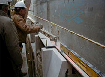 Photo showing foam sealant applied to all insulation board edges followed by peel-and-stick modified asphalt tape on the primed insulation sheathing boards used as the air barrier
