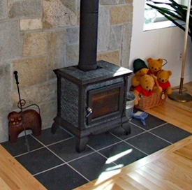 An efficient black wood burning stove in the living room of a new home