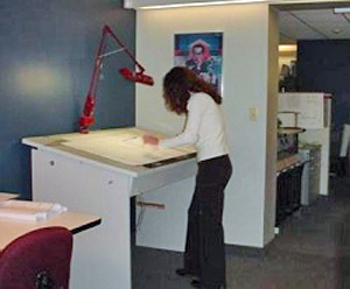 woman using a standing workstation in her workplace