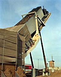 Image of a generation station with a large skip of woody materials from the agricultural industry being loaded into it.