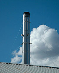 Photo of an exhaust stack on a biomass system on the roof of a California greenhouse