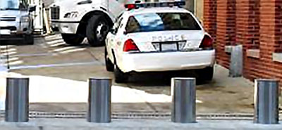 four steel active electric bollards outside a police station