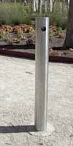 single stainless steel bollard secured in gravel in park
