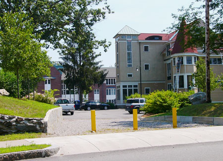 Image of Lasell College in Newton, MA with three yellow bollards at the entrance