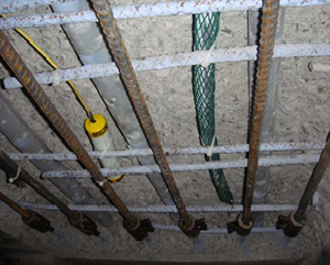 concrete deck repair with discrete zinc anode (wrapped in green mesh) and permanent reference electrode (yellow lead wire)