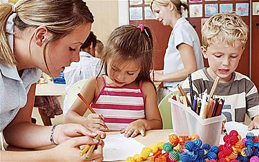 Adult observing a girl and a boy in a classroom setting