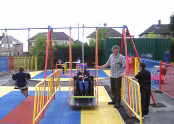 child in a wheelchair accessible swing