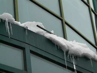 Detail of the side of a building with ice pushing out a piece of barrier trim