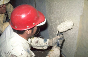 Photo of worker rolling coating on wall surface