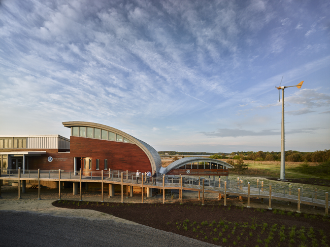 Exterior of the Brock Environmental Center with view of the elevated entry ramp, and roof forms resembling gull wings that allow for rainwater collection.