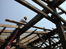 Worker deconstructing a wooden structure