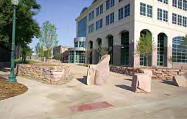 Public plaza created between buildings featuring stone bollards and stone walls