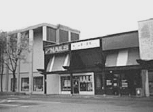 B/W photograph of a sidewalk and storefronts