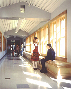 Elementary school featuring room like corridors with kids sitting on hallway window benchs and windows between classrooms provide views in and out