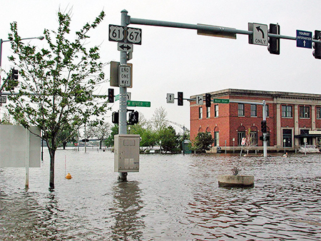 Photo of Mississippi River flooding a downtown with water levels high on a stoplight