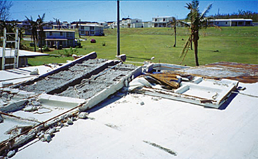 Photo of a waffled precast concrete roof deck where portions were blown off because anchor plates and nuts had not been installed