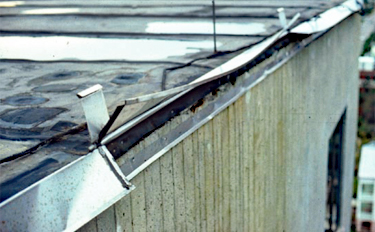 Vertical flange on metal flashing disengaged and lifting up