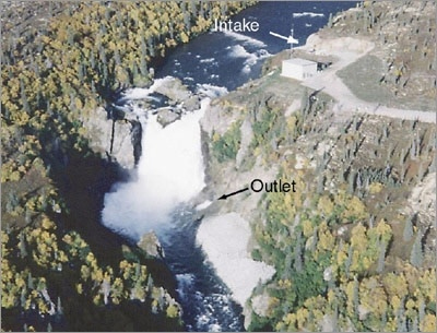 Photo of the Tazimina project in Alaska showing an intake on the upper part of a river, with the water flowing down a waterfall into an outlet on the lower part of the river