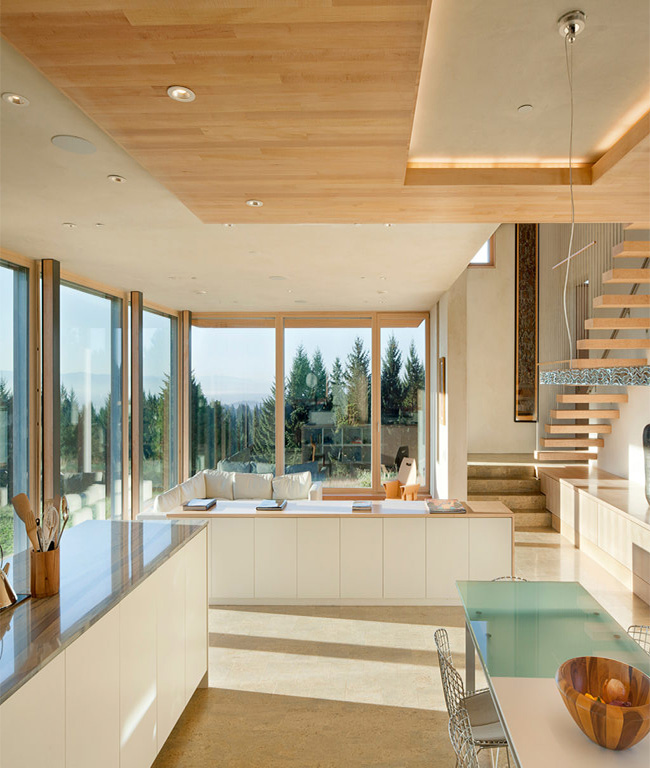 interior of the Karuna House, Porland Oregon facing out from the kitchen with views of the staircase, living room and outdoor views