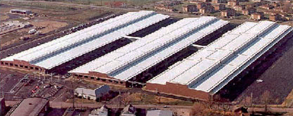 Aerial view showing three side-by-side buildings with high reflective roofs