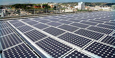 Photo of sloped PV panels, shown on customer's roof against a city backdrop