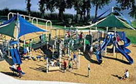 View of a playground showing the gross motor play zone equipped with slides, climbing apparatus, etc.
