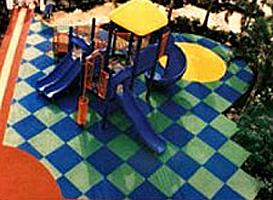 Playground surfaced with poured-in-place rubber and rubber mats