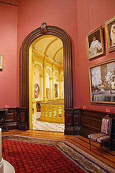 Renwick Gallery, Smithsonian American Art Museum's Octagon Room to Grand Stair Hall prior to renovation with dark coral-colored walls and dark wood trim