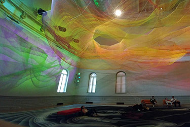 Grand Salon in the Renwick Gallery after renovation showing the installation by Janet Echelman called 1.8, whose swirls of colors and form throughout the space captures the power of the Japanese earthquake from 2011