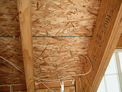 Interior view of construction with SIPs wall and roof panels showing seeping of sealant at SIP joints