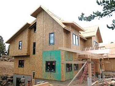 Side view of house construction using SIPs for wall and roof panels in a complicated architectural form