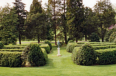 Manicured landscaping featuring a base and statue in a clearing surrounded by hedges on a Virginia Country estate