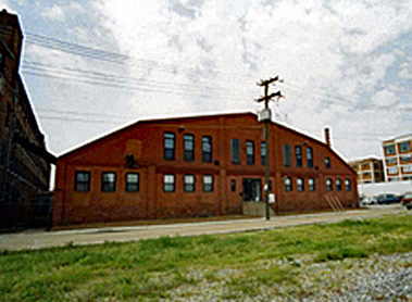 Exterior of a large red brick building with a barn shaped roof