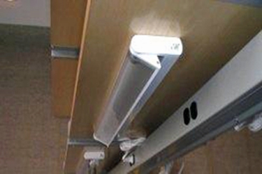Overhead task light secured under shelving
