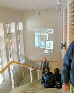 Atrium staircase in Stanford University's Wallenberg Hall with students work projected on the wall