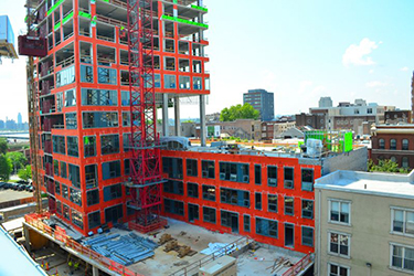 VaproShield WrapShield SA, shown in orange, installed on the Bridge apartment building during construction