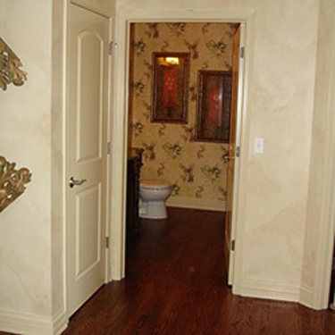 hallway showing the open door of a half-bath on the ground floor of a home
